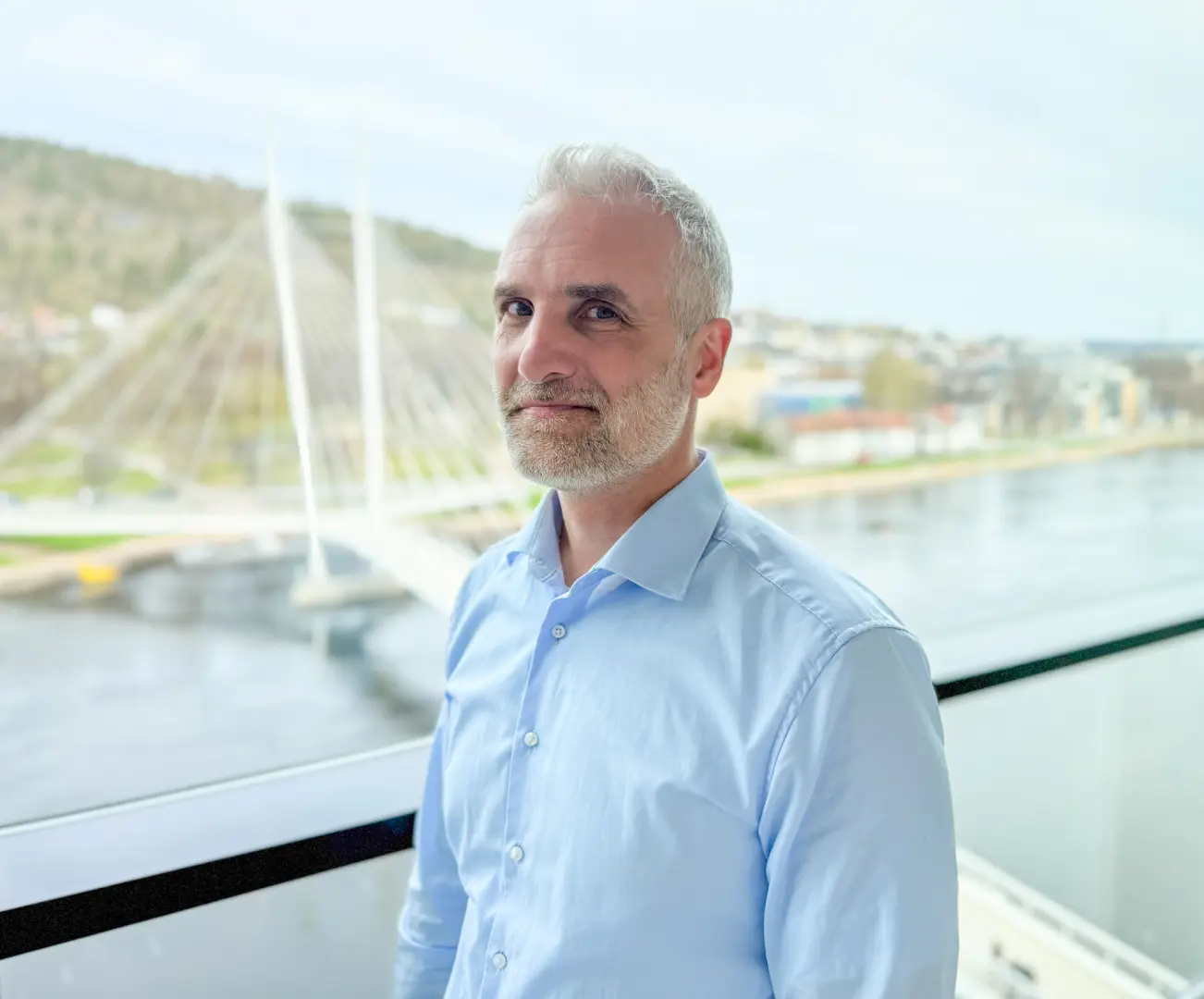 Førsteamanuensis Søren Obed Madsen er fagansvarlig for emnene i strategisk ledelse. Her står han på campus Drammen med utsikt over elva og Ypsilon bru.