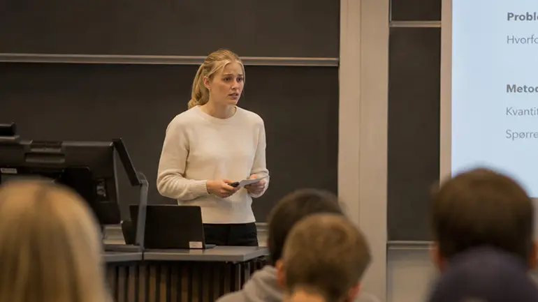 Jente holder presentasjon foran klassen