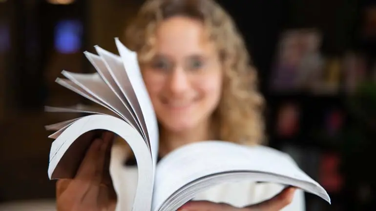 Jente som blar i bok