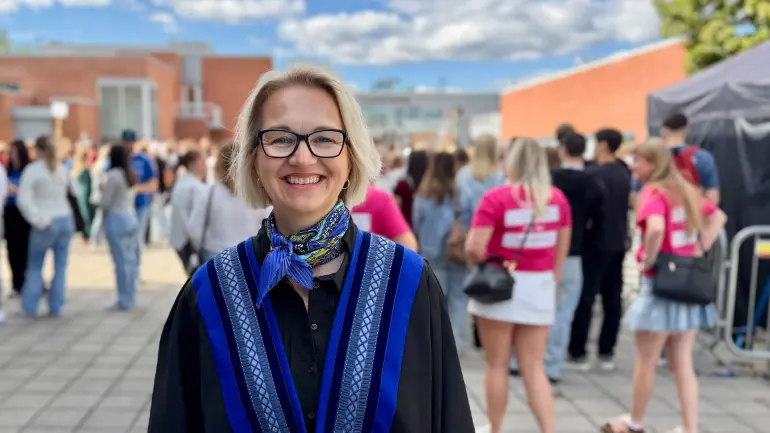 rektor Pia Bing-Jonsson smiler på campus Porsgrunn foran årets studentkull