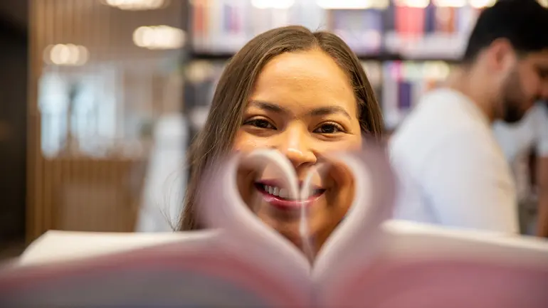 Jente ser gjennom et hjerte i en bok 