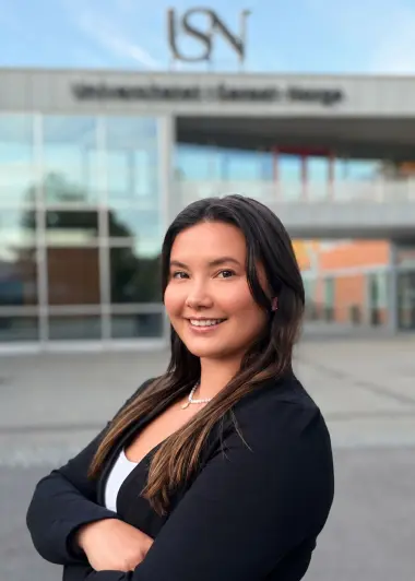 Portrett av Thea Lucia Sauro Indrebø foran campus Porsgrunn