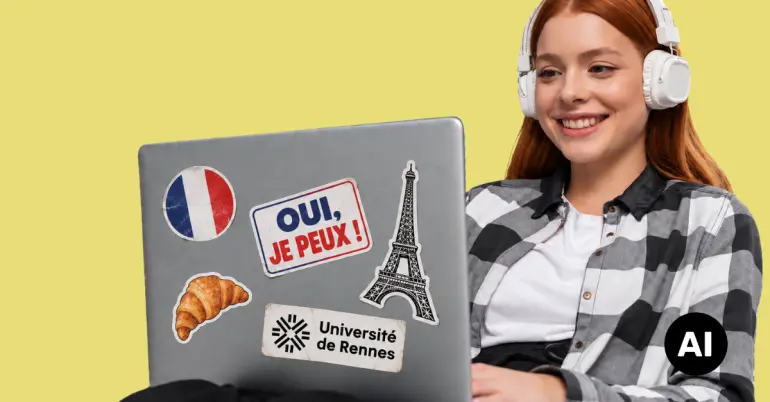 Kvinne som holder en laptop dekket av klistremerker fra Frankrike.