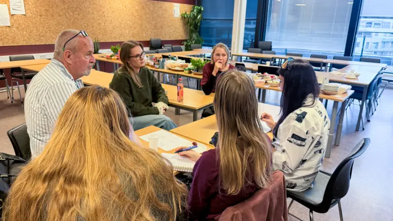 Senior lecturer Theo Sikkes and students around table