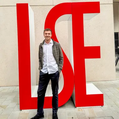 Martias Flikka ved logoen til London School of Economics