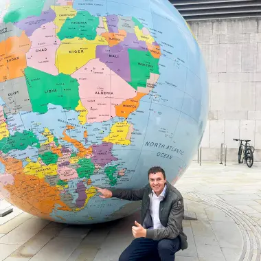 Martias Flikka ved globus utenfor London School of Economics
