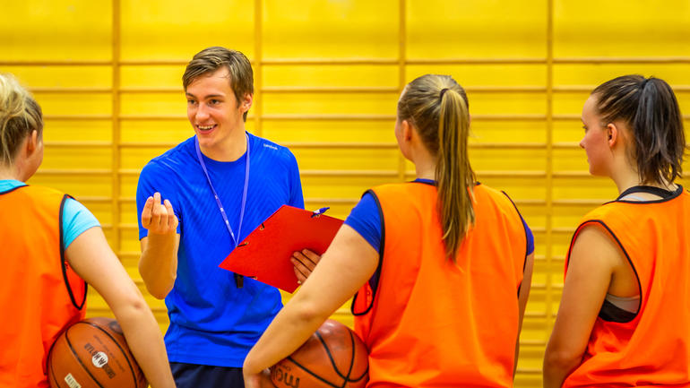 Studenter på idrett coacher i basketball
