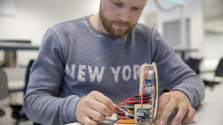 Nærbilde av en ingeniørstudent gutt foran elektronikkarbeid