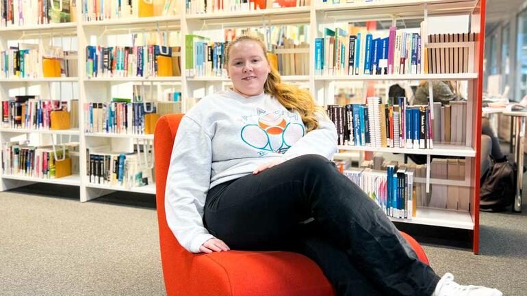 Maren tar bachelor i økonomi og ledelse på campus Kongsberg. Bilde av henne på biblioteket.